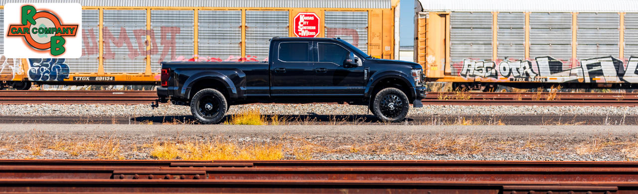 Lineup of used dually pickup trucks for sale at the R&B Car Company Fort Wayne dealership lot.