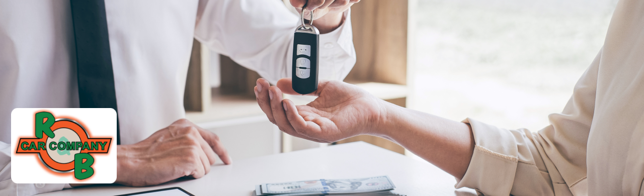 Customer reviewing car purchase paperwork with a dealership representative.