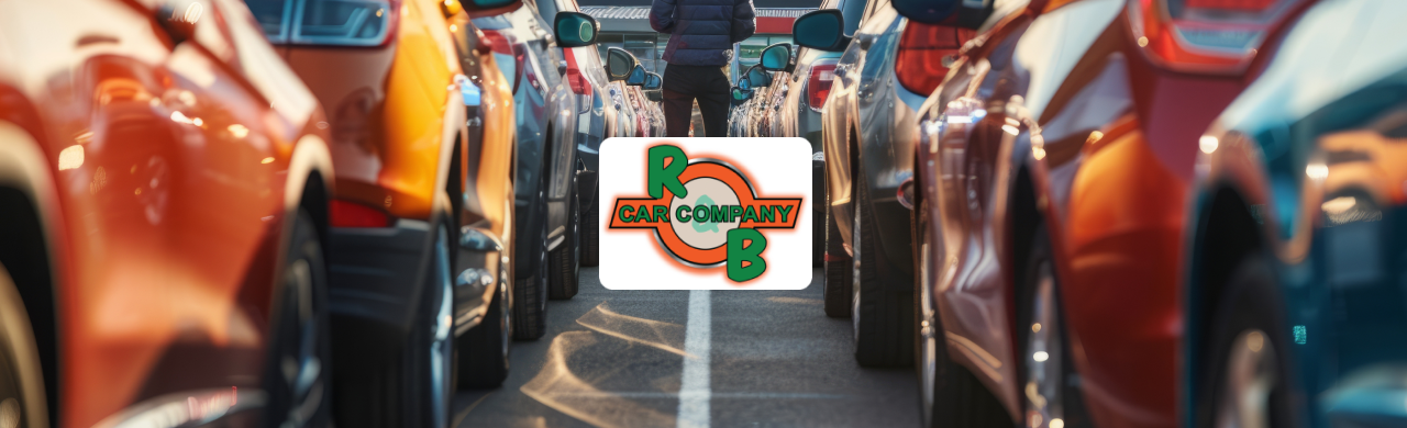 A row of cars parked in a lot with a camera view going through the aisle. 