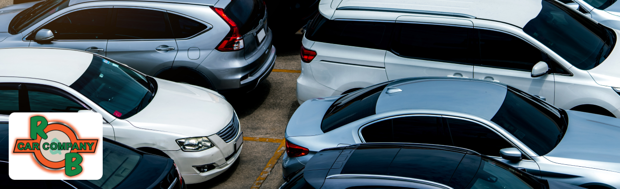  A row of parked cars in a parking lot showcasing a variety of colors and models